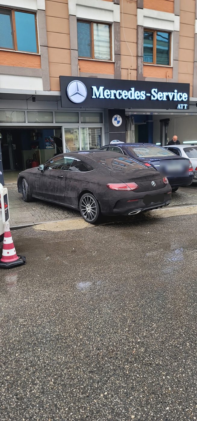 Mercedes-Service tabelası ve servis önünde Mercedes-Benz C-Serisi Coupe